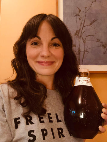 Free Spirit Stephanie Bar holding a bottle of Freeland Bourbon